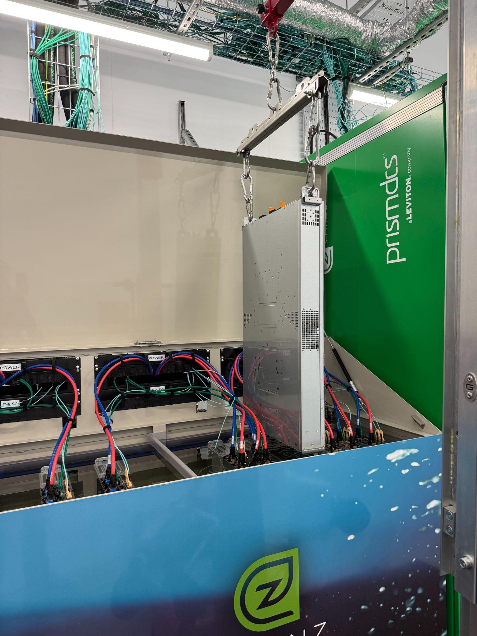 Server hardware being lowered into an immersion cooling tank