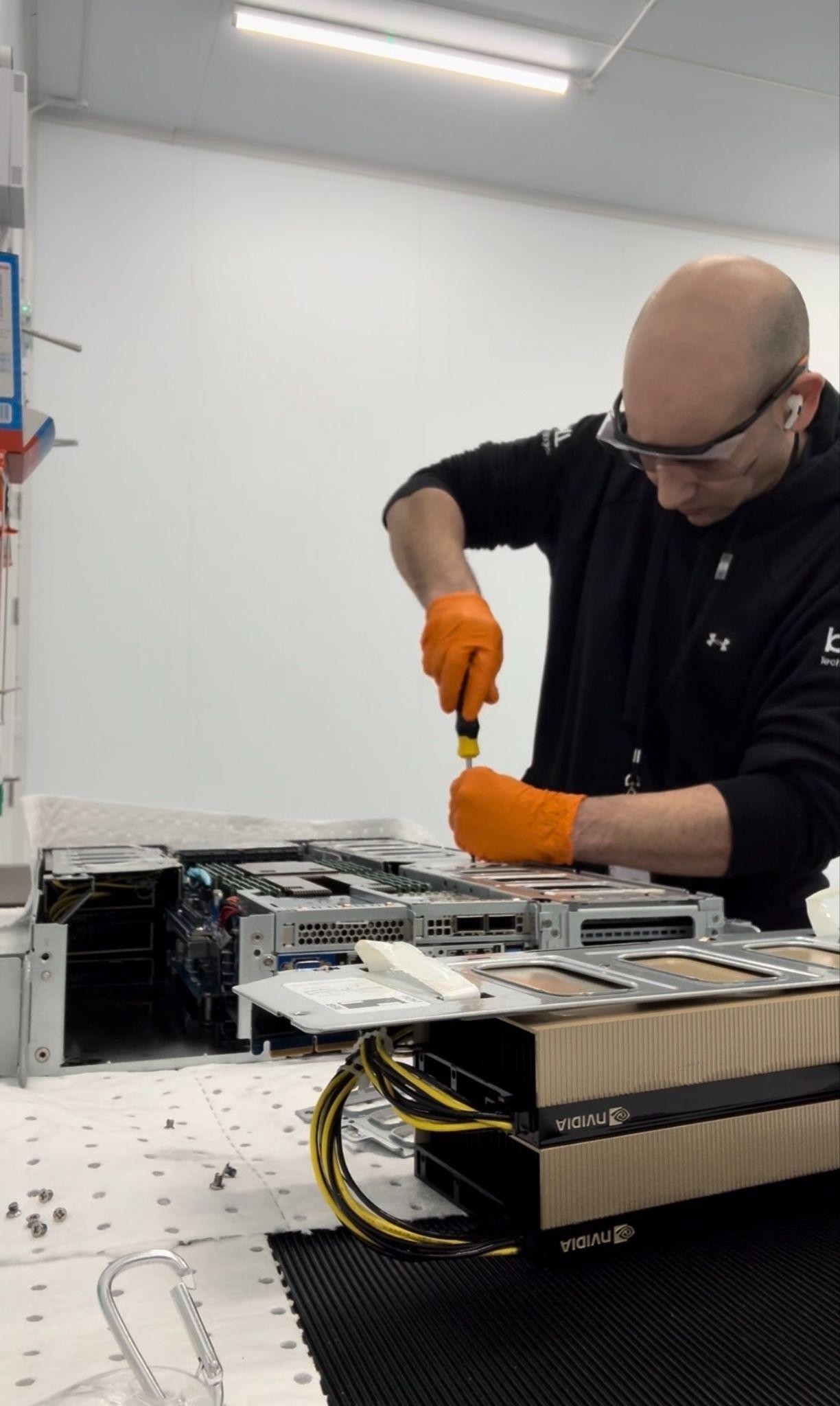 Technician servicing server hardware for an immersion cooling deployment